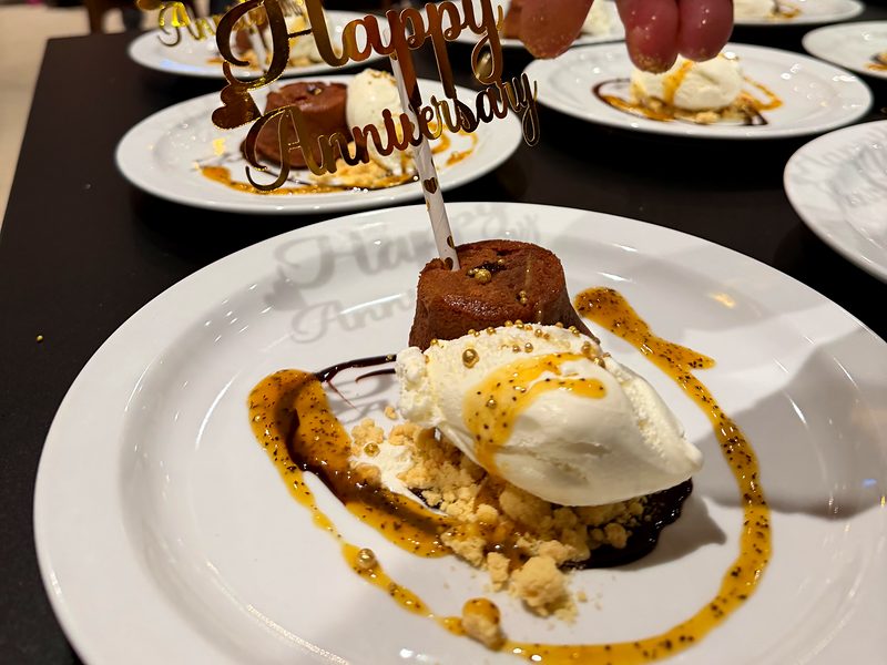 A dessert with a Happy Anniversary topper, plated for a celebration dinner in a villa
